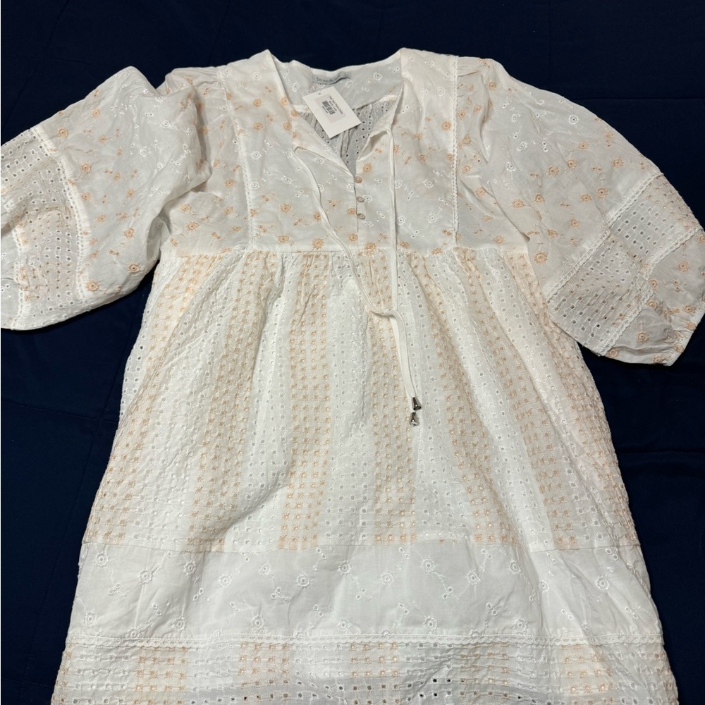 White dress with tan colored flowers on it. Brand new still has tags on it.